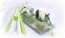 Gesteck mit Kerze in moderner Draht-Sisal-Tasche. Tolle und trendige Tischdekoration in silber und grün weiß
