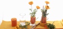 Tischdeko gelb orange, mit Frühlingsblumen und Wollband in Glasvase kreativ arrangiert